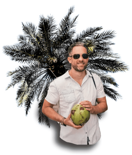 Tim Hubbard traveling — coconut in hand, palm tree behind